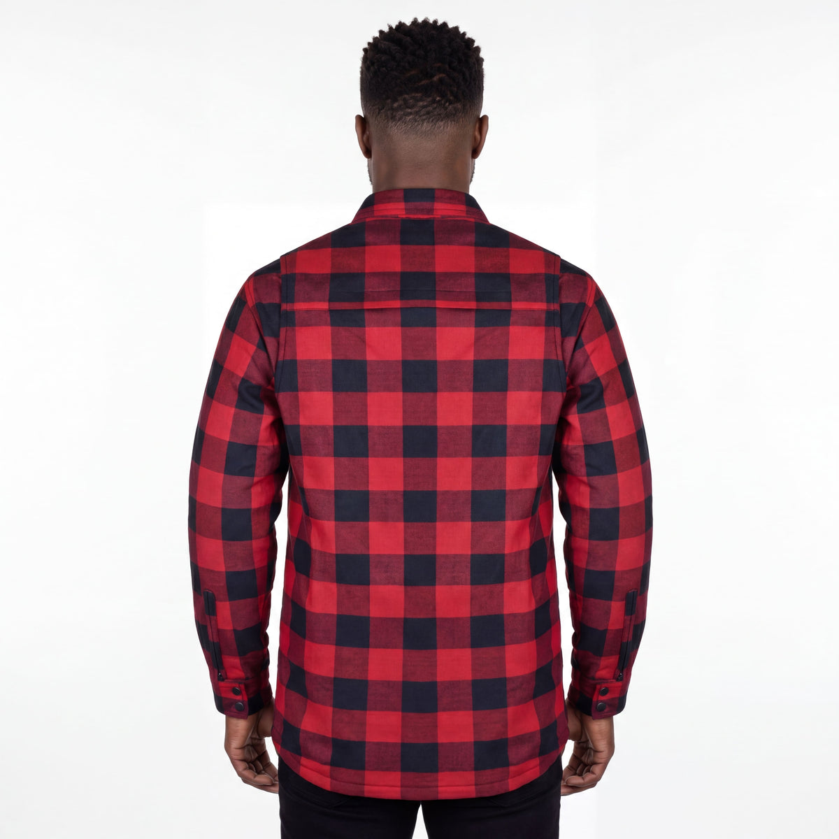 Rear view of a model wearing a red and black plaid motorcycle flannel shirt with a curved hem.